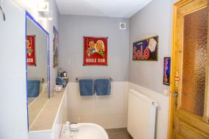 a bathroom with a sink and a toilet and signs at B&B Chez tante Alice in Durbuy