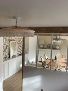 a dining room with a table and a mirror at Maison Charmille in Féricy
