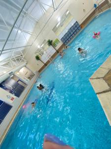a group of people swimming in a swimming pool at Apartment with Access to Pool Spa & Soft play in Ilfracombe