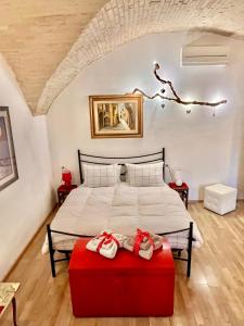a bedroom with a large bed with a red ottoman at Spello Vacanze Dante's House piano terra in Spello