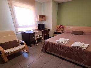 a bedroom with a bed and a desk and a chair at The Factory Residence Hall in Segovia