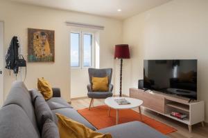 a living room with a couch and a tv at Madeira Friendly Guest House by An Island Apart in Funchal