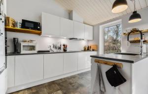 a kitchen with white cabinets and a black counter top at 5 Bedroom Nice Home In Fårevejle in Fårevejle