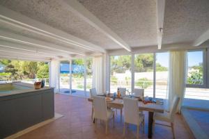 a kitchen and dining room with a table and chairs at Le Secche Suite & House 1 by Salento Prime in Torre Pali 