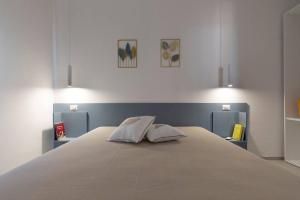 a bedroom with a large white bed with two pillows at Le Secche Suite & House 1 by Salento Prime in Torre Pali 