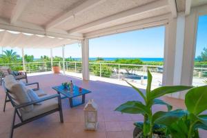 a patio with chairs and a table and a view of the ocean at Le Secche Suite & House 2 by Salento Prime in Torre Pali 
