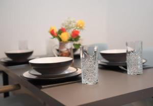 a table with plates and glasses on a table at The Galloway Steading - The Stag Hoose family cabin with Preheated Hot Tub and Fire Pit in Glenluce
