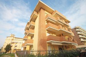 a tall building with a fence in front of it at Soffio di mare in Alba Adriatica