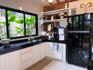a kitchen with white cabinets and a black counter top at Ocean Villa - Private Pool House with Sea View in Putatan