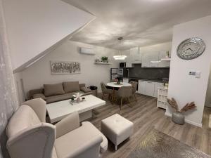 a living room and kitchen with a couch and a table at LaMira 2,3 Apartments in Hajdúszoboszló