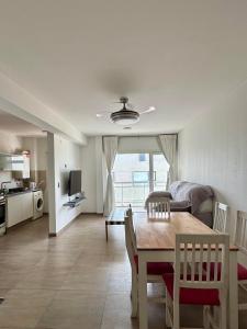 Una sala de estar con una mesa de comedor y una cocina. en Mi Ruca, en Puerto Madryn