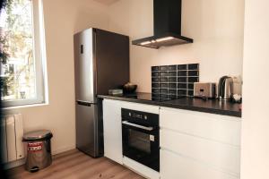 a kitchen with a refrigerator and a stove at La SUITE'HOME Super Bright Modern Apartment in Mulhouse +10 photos