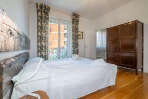sypialnia z białym łóżkiem i oknem w obiekcie Maison Al Parco w Bergamo