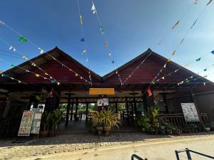 a building with awning with plants and signs on it at MR Mo Guest House in Along