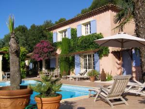 una villa con piscina con sedie e ombrellone di le Mas des Cigales a Tourrettes-sur-Loup