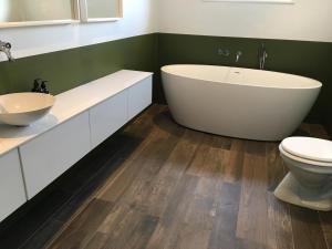 a bathroom with a large tub and a toilet at Tana Panorama - Apartments in Tana