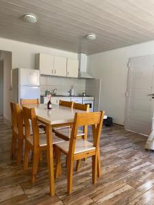 a dining room with a table and chairs and a kitchen at 4 Estaciones Departamentos in Sierra de la Ventana