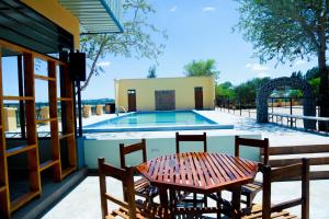 a table and chairs next to a swimming pool at KBH by Royal Village in Singida