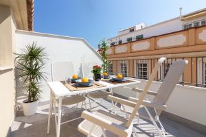 a patio with a table and chairs on a balcony at GRUND SUITES GALLERY by FreshApartments in Málaga