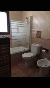 a bathroom with a toilet and a tub and a sink at Majaceite in El Bosque +9 photos
