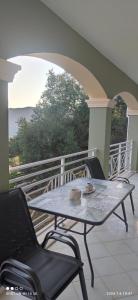 a patio with a table and chairs on a balcony at Loukas House 1Σταυρος-Κερκυρα Μακράτα in Stavrós