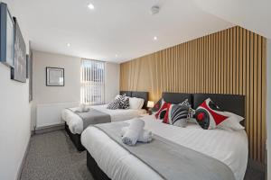 a hotel room with two beds with stuffed animals on them at Burnand House - Air Host & Stay - Sleeps 9 in Liverpool