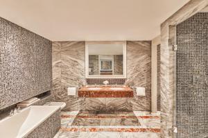 a bathroom with a tub and a sink at Hôtel Barrière Le Majestic Cannes in Cannes