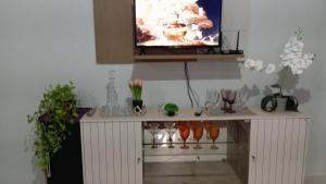 a tv sitting on top of a table with flowers at Apartamento mobiliado no centro, Siqueira Campos, in Santarém