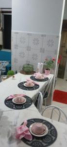 a table with four plates with pink roses on them at Apartamento mobiliado no centro, Siqueira Campos, in Santarém +3 photos