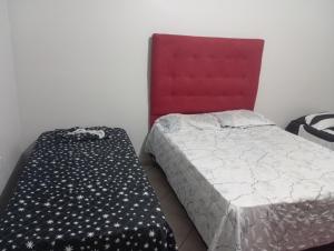 a bedroom with a bed and a red head board at Apartamento mobiliado no centro, Siqueira Campos, in Santarém