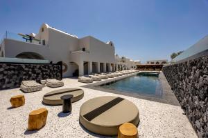 a resort with a swimming pool and some chairs at Santo Mangata Boutique Hotel and Spa in Perissa