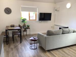 a living room with a couch and a table at 8 Ashbrook Mews in Blewbury