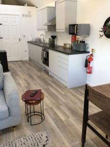Una sala de estar con un sofá y una cocina. en 8 Ashbrook Mews, en Blewbury