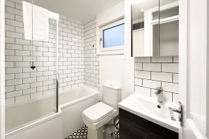 a white bathroom with a toilet and a sink at 6-Bedroom Contractor House with 9 Beds - Managed by Your Lettings Short Lets & Serviced Accommodation Peterborough including Free Parking and WiFi and Netflix in Peterborough +19 photos