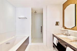 a white bathroom with a tub and a sink at Hôtel Barrière Le Majestic Cannes in Cannes