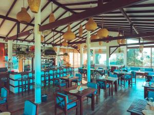 a restaurant with wooden tables and blue chairs at Ella Soul Resort in Ella