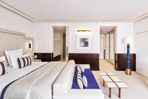 a hotel room with a large bed and a couch at Hôtel Barrière Le Majestic Cannes in Cannes