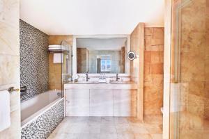 a bathroom with a tub and a sink and a mirror at Hôtel Barrière Le Majestic Cannes in Cannes