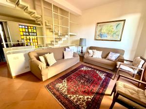 a living room with two couches and a rug at Marilù e il Mare - Your home by the sea in Aci Castello +33 photos
