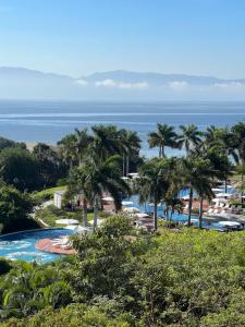 a view of a resort with palm trees and the ocean at Vidanta Nuevo Vallarta Grand Luxxe 3 Bedroom Spa in Nuevo Vallarta 