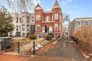 a red brick house with a gate in front of it at Spacious and Central DC 3-BR Getaway Close to It All in Washington, D.C.