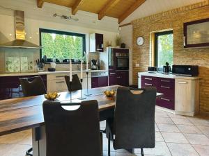 Una cocina con una gran mesa y sillas de madera. en Am Hang, en Blankenburg