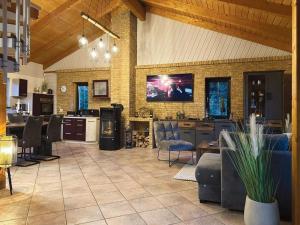 Una cocina y una sala de estar con televisión y un sofá. en Am Hang, en Blankenburg