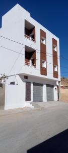 ein weißes Gebäude mit Balkonen an der Seite in der Unterkunft Dar MORTADA TATAOUINE in Tataouine + 34 Fotos