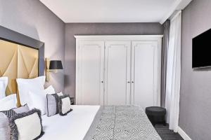 a bedroom with a large white bed with pillows at Hôtel Barrière Le Majestic Cannes in Cannes