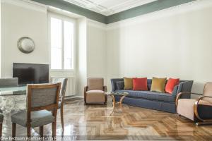 salon z niebieską kanapą i krzesłami w obiekcie Brera Apartments w Mediolanie