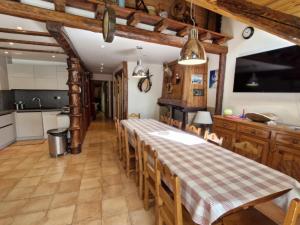 une salle à manger avec une table et une cuisine dans l'établissement Chalet 11 pers, 5 ch, pied des pistes, balcon, parking, Wi-Fi, cheminée, Serre Chevalier - FR-1-762-27, à Saint-Chaffrey