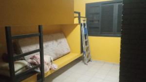 a room with two bunk beds and a yellow wall at Casa com piscina in Guarujá