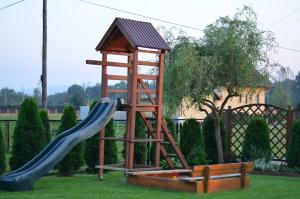 a playground with a slide and a play structure at Gospodarstwo Agroturystyczne Stajnia Grudki Energylandia Zator in Zator