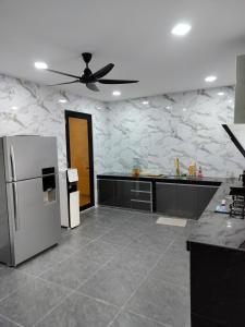 a kitchen with a refrigerator and a ceiling fan at KLANG - Enjoy Life Klang Homestay in Klang